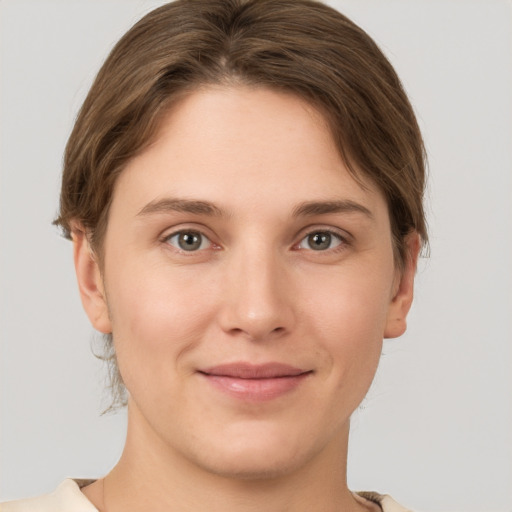 Joyful white young-adult female with short  brown hair and grey eyes