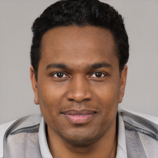 Joyful black young-adult male with short  black hair and brown eyes