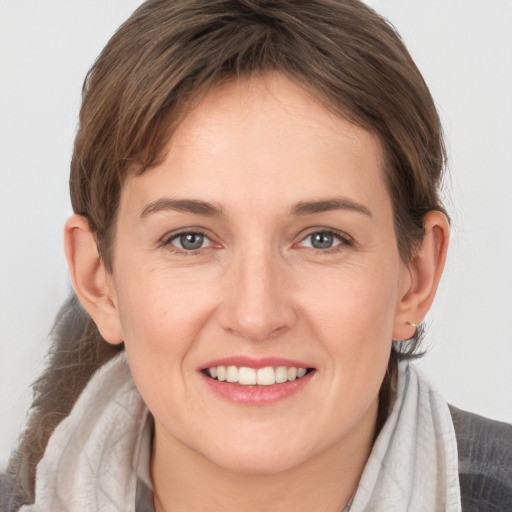 Joyful white young-adult female with medium  brown hair and grey eyes