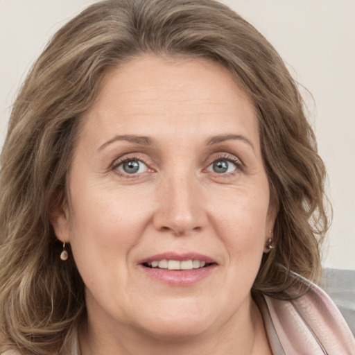 Joyful white adult female with medium  brown hair and grey eyes