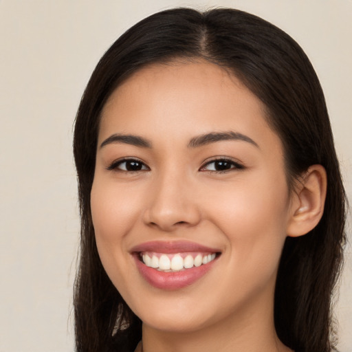 Joyful latino young-adult female with long  brown hair and brown eyes