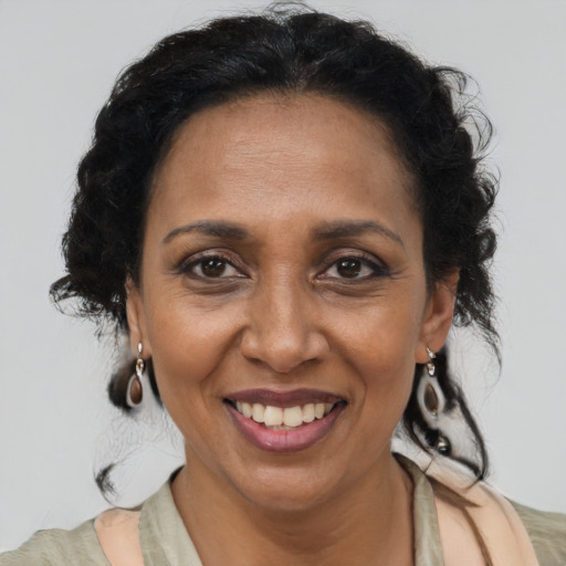 Joyful black adult female with long  brown hair and brown eyes