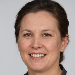 Joyful white adult female with medium  brown hair and grey eyes