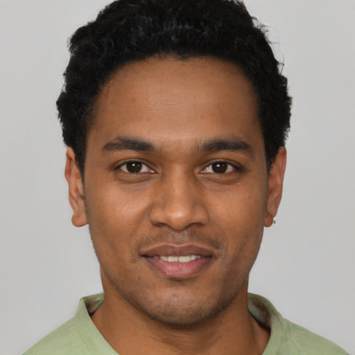 Joyful black young-adult male with short  black hair and brown eyes