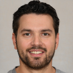 Joyful white young-adult male with short  black hair and brown eyes