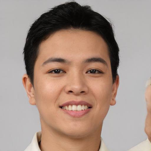 Joyful asian young-adult male with short  brown hair and brown eyes