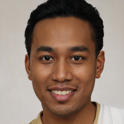 Joyful black young-adult male with short  black hair and brown eyes