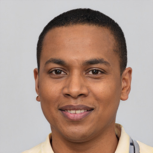 Joyful black young-adult male with short  black hair and brown eyes