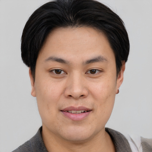 Joyful asian young-adult male with short  brown hair and brown eyes
