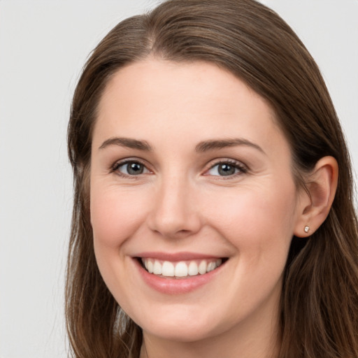 Joyful white young-adult female with long  brown hair and grey eyes