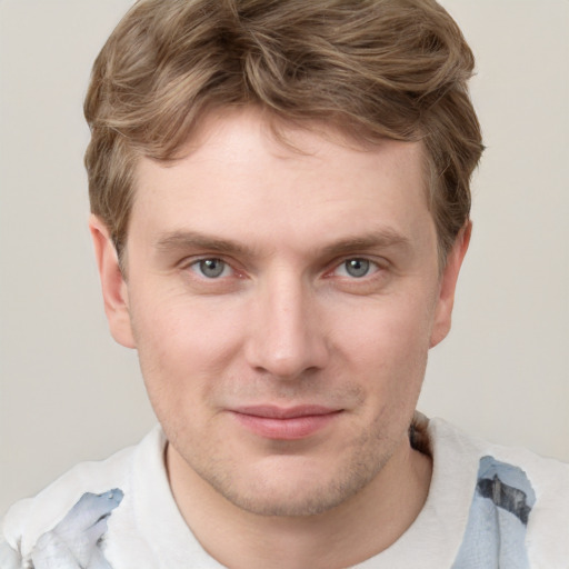 Joyful white young-adult male with short  brown hair and grey eyes