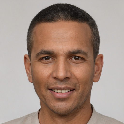 Joyful latino adult male with short  black hair and brown eyes