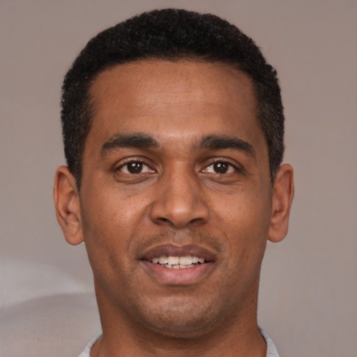 Joyful black young-adult male with short  black hair and brown eyes