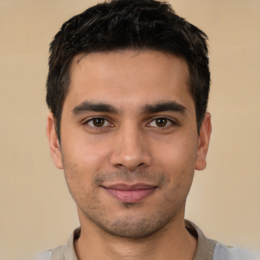 Joyful latino young-adult male with short  brown hair and brown eyes