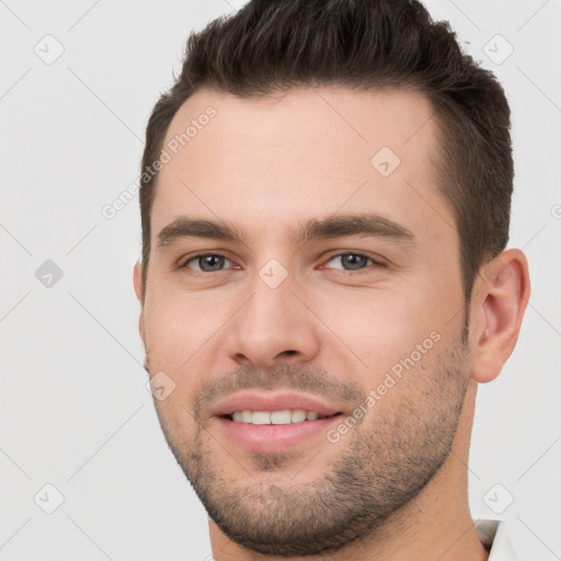 Joyful white young-adult male with short  brown hair and brown eyes