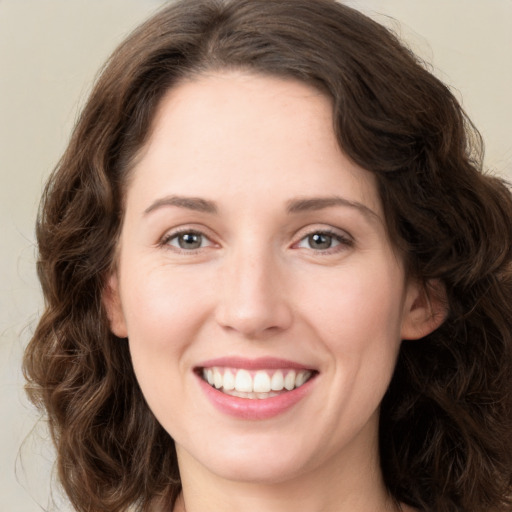 Joyful white young-adult female with long  brown hair and green eyes