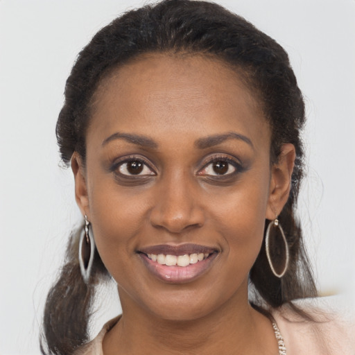 Joyful black young-adult female with long  brown hair and brown eyes