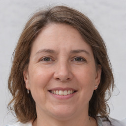 Joyful white adult female with medium  brown hair and grey eyes