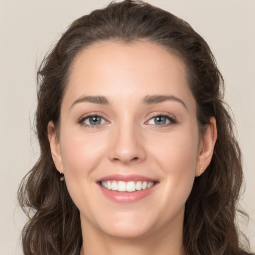 Joyful white young-adult female with long  brown hair and grey eyes