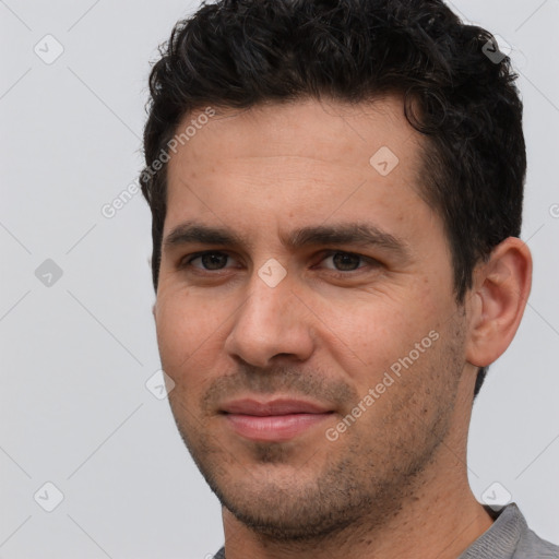 Joyful white young-adult male with short  black hair and brown eyes