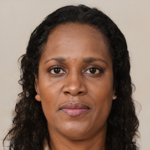 Joyful black adult female with long  brown hair and brown eyes