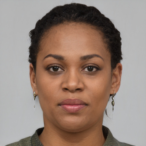Joyful black young-adult female with short  black hair and brown eyes