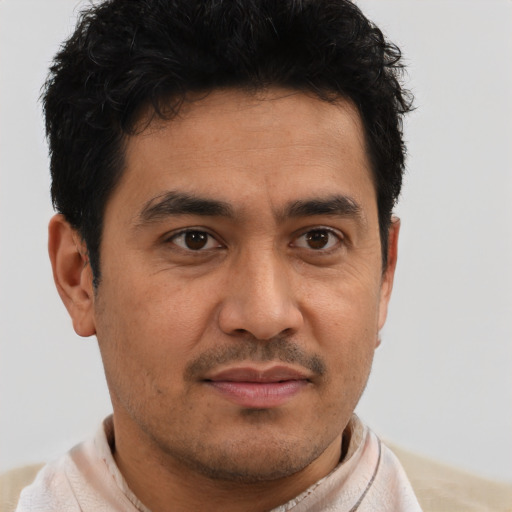 Joyful latino young-adult male with short  brown hair and brown eyes