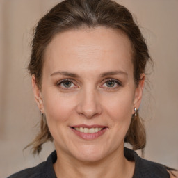 Joyful white adult female with medium  brown hair and grey eyes