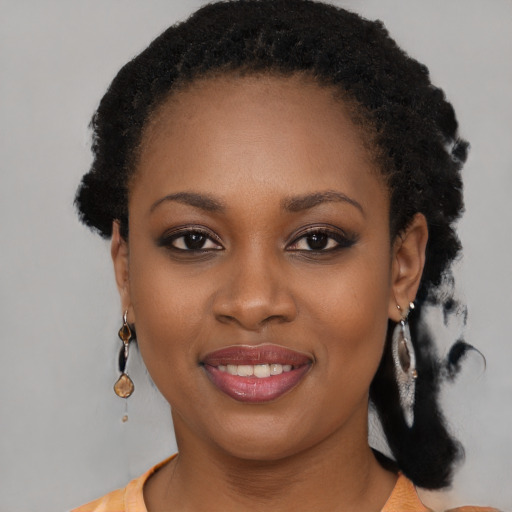 Joyful black young-adult female with long  black hair and brown eyes