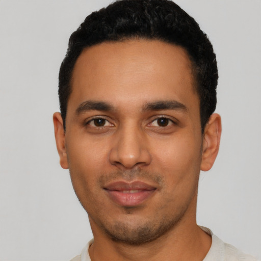 Joyful latino young-adult male with short  black hair and brown eyes