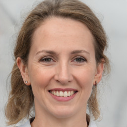 Joyful white adult female with medium  brown hair and grey eyes