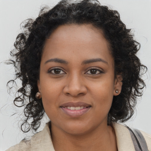 Joyful black young-adult female with long  brown hair and brown eyes