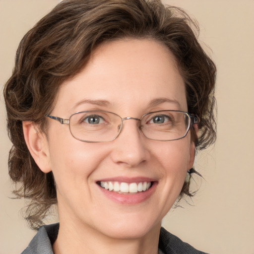 Joyful white adult female with medium  brown hair and blue eyes