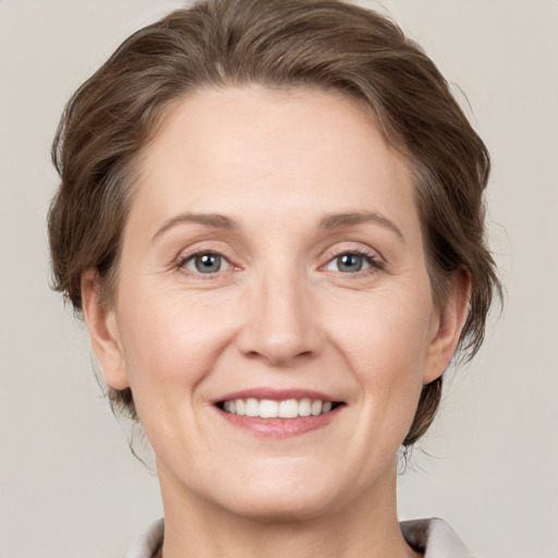 Joyful white adult female with medium  brown hair and grey eyes