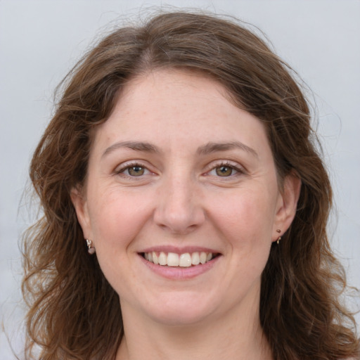 Joyful white young-adult female with long  brown hair and grey eyes