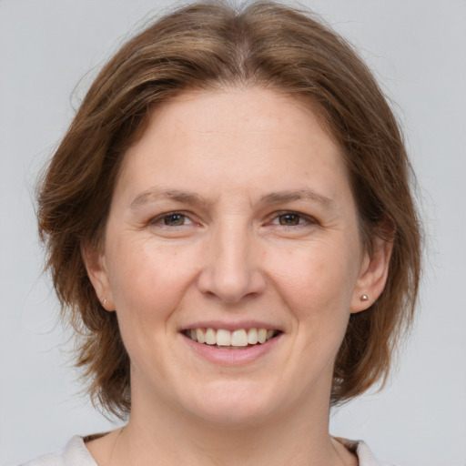 Joyful white adult female with medium  brown hair and brown eyes