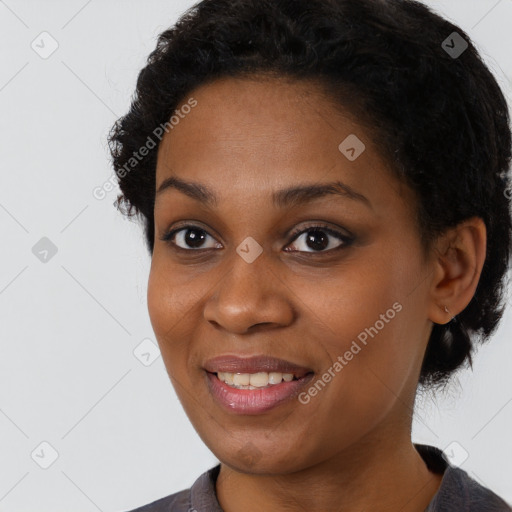 Joyful black young-adult female with short  black hair and brown eyes