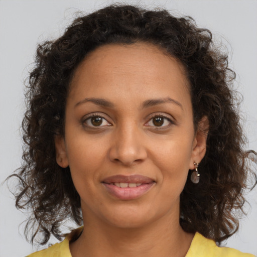 Joyful latino adult female with medium  brown hair and brown eyes