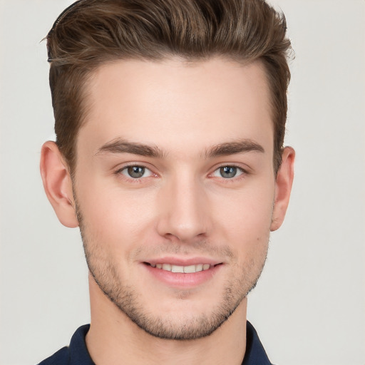 Joyful white young-adult male with short  brown hair and grey eyes