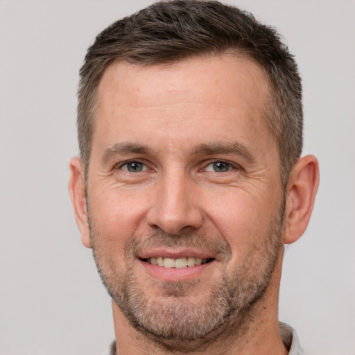 Joyful white adult male with short  brown hair and brown eyes