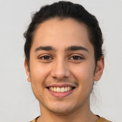 Joyful latino young-adult male with short  brown hair and brown eyes