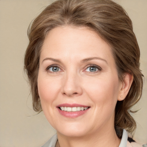 Joyful white adult female with medium  brown hair and grey eyes