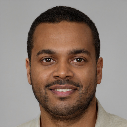Joyful black young-adult male with short  brown hair and brown eyes
