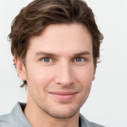 Joyful white young-adult male with short  brown hair and grey eyes