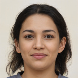 Joyful latino young-adult female with medium  brown hair and brown eyes