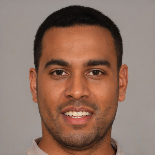 Joyful black young-adult male with short  black hair and brown eyes