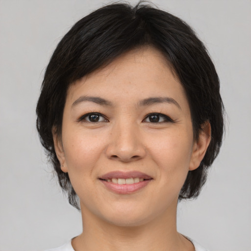 Joyful asian young-adult female with medium  brown hair and brown eyes