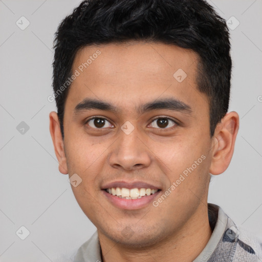 Joyful latino young-adult male with short  black hair and brown eyes