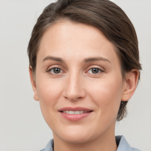 Joyful white young-adult female with medium  brown hair and grey eyes