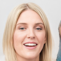 Joyful white young-adult female with long  brown hair and blue eyes